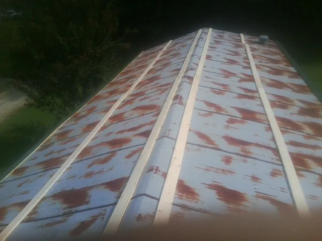 Rusted metal roof panels with new wood purlins before replacement — Storm Damage Roof Repair in Brush Creek by Roofing Brothers