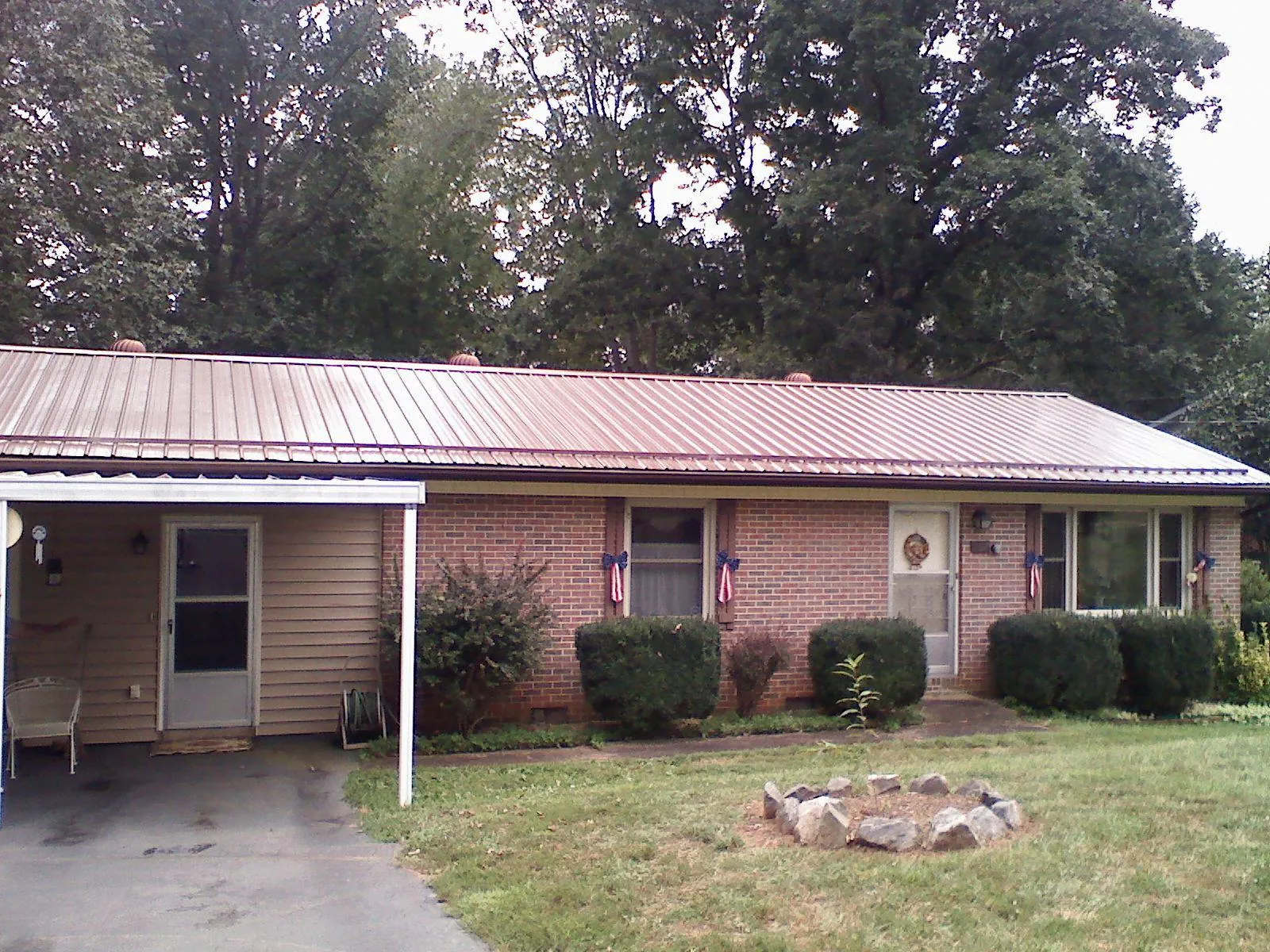 Bronze metal roof and carport on a brick ranch home — Roof Repair work by our crew in Brush Creek