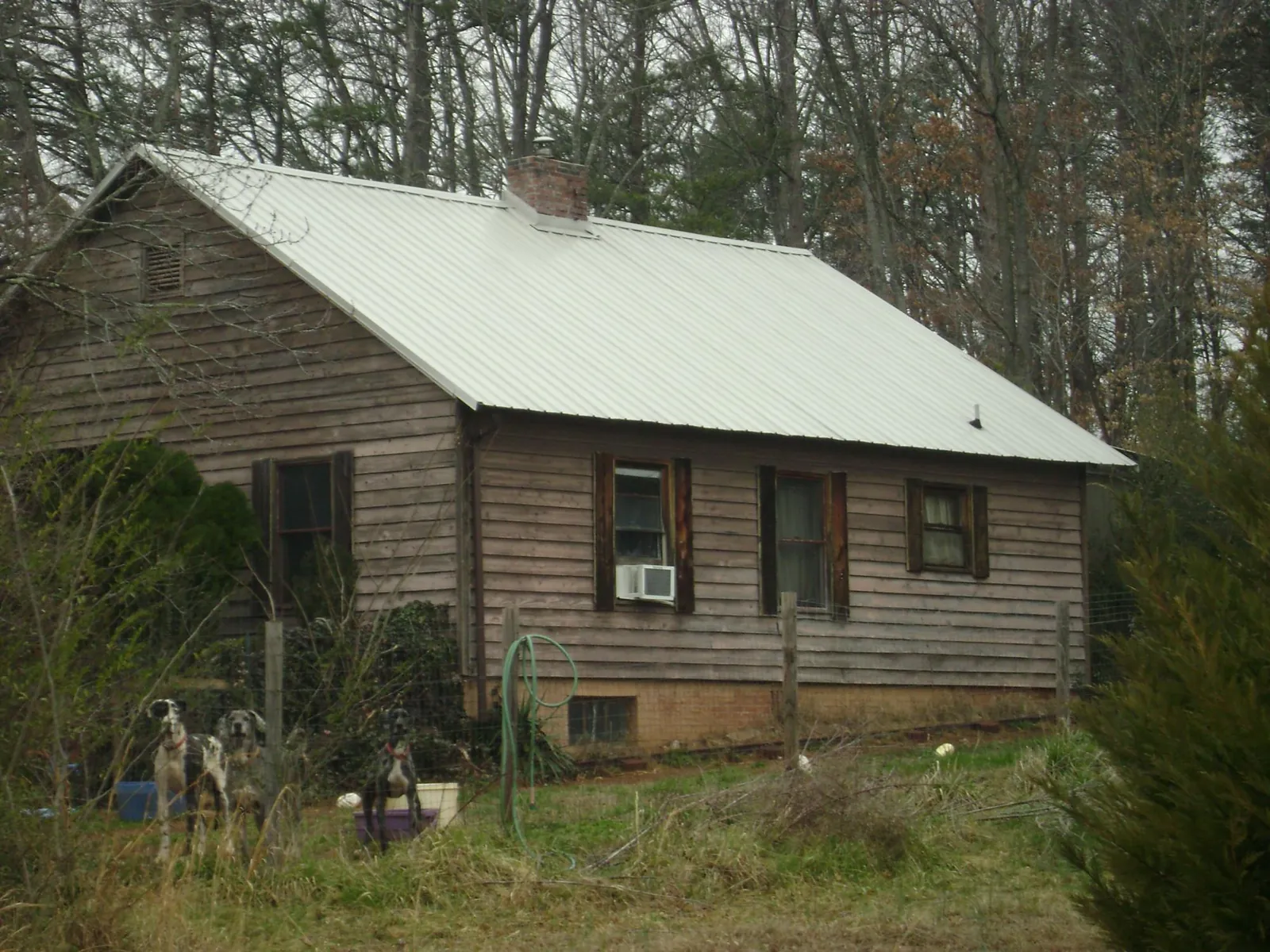 White metal roof on an old wood sided farmhouse, from a Metal Roof Installation job in Brush Creek